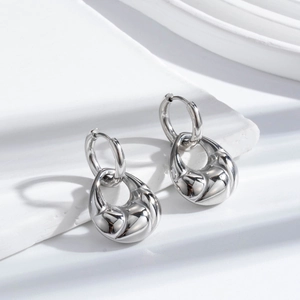 Polished stainless steel croissant hoop earrings in French vintage style on white blocks