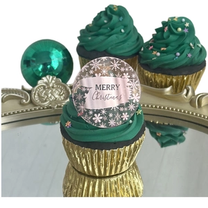 Macro view of acrylic Christmas cupcake topper with pink snowflake and Merry Christmas text