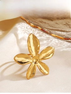 Détail macro d'une bague fleur plaquée or 18 carats sur satin de luxe et verre