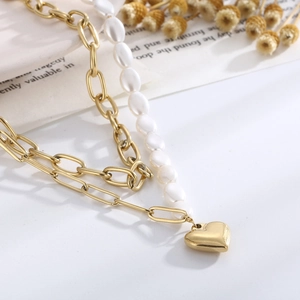 Detail of freshwater pearl and gold heart pendant necklace with dual chain textures
