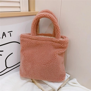 Dettaglio della borsa a mano rosa in peluche con texture soffice in lana d'agnello e manici