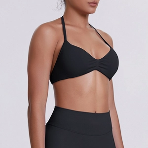 Close-up of black seamless halter sports bra with high-waisted leggings on model