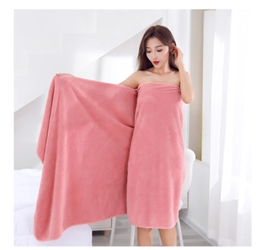 Pink coral fleece bath towel with waffle texture shown on model in a bright room
