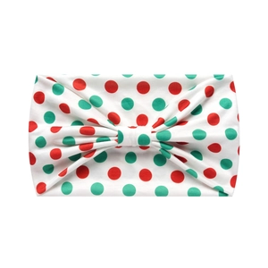 Detail of soft elastic headband featuring red and green polka dot pattern with a center knot