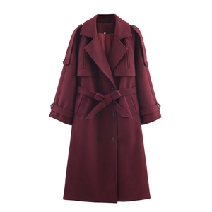 Detail of burgundy double-breasted coat featuring classic waist belt and epaulette design