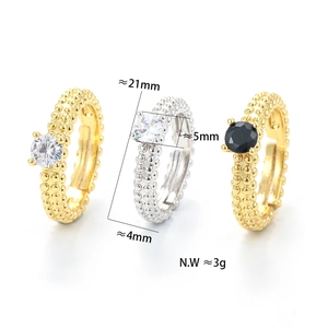 Detail view of gold and silver beaded rings with cz zircon four-prong settings