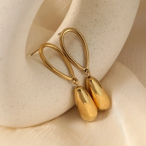 French style gold teardrop earrings in polished stainless steel on a ceramic stand