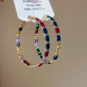 Detail of colorful rainbow zircon hoop earrings with vibrant rectangular cut stones