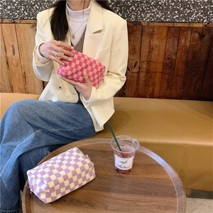 Detail of soft knitted checkerboard makeup bag with high-quality metal zipper closure