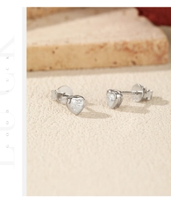 Macro detail of S925 sterling silver heart stud earrings with sparkling Moissanite stones