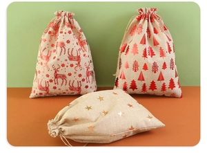 Detail of Christmas burlap gift bags with golden reindeer and tree prints and drawstring