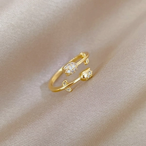 Macro detail of gold tulip ring with sparkling micro-diamonds on champagne satin fabric