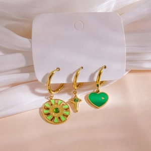 Three-piece gold earring set with green enamel charms on a white jewelry card
