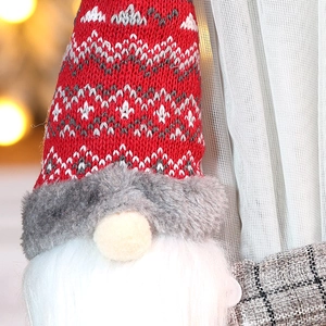 Detailed view of plush Christmas gnome with red knitted hat and white faux fur beard