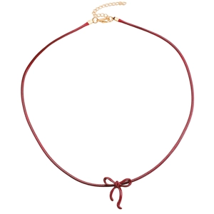 Macro view of dark red bow pendant on fine leather cord with golden adjustable clasp