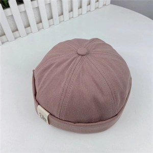 Detail of dust pink cotton docker hat with roll-up brim and white 'CLUB' logo patch