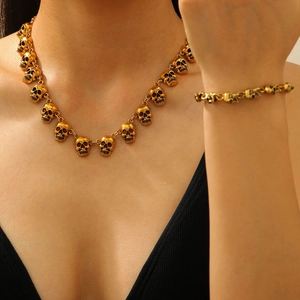 Detailopname van een gothische gouden schedel ketting en armband set voor Halloween