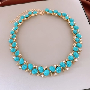 Detailed view of a vintage gold necklace featuring turquoise stones and crystal accents