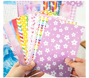 Handheld fan-shaped display of colorful scrapbooking paper with floral and heart patterns
