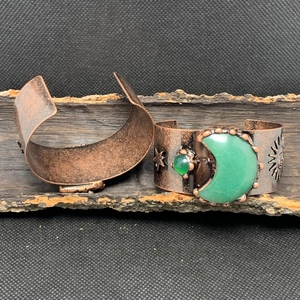 Detailrelief von Himmelsonne und Sternen auf einem Vintage Bronze Manschettenarmband