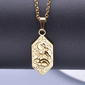 Macro shot of 18k gold hexagon rabbit and moon pendant on black leather background