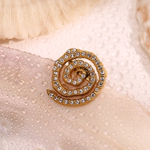 Detailed view of an 18K gold-plated vortex brooch with micro-pave white crystals