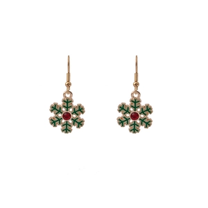 Detail of gold snowflake earrings with green enamel petals and a central red rhinestone