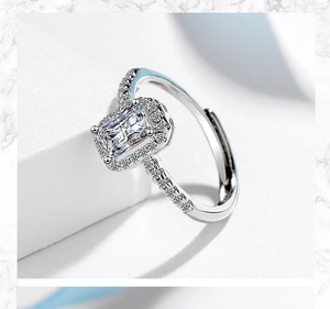 Macro shot of silver ring with radiant-cut center stone and pave-set halo of cubic zirconia