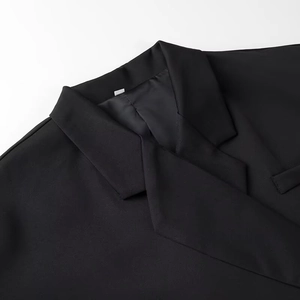 Detail view of the black oversized blazer's notch lapel with premium fabric texture