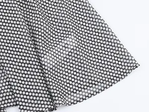 Detailed close-up of tiered polka dot chiffon fabric with professional hem stitching