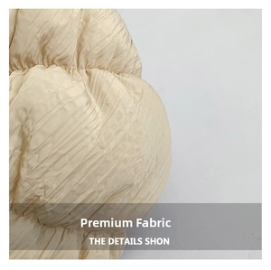 Macro shot of the beige pleated fabric texture on a soft cloud-style shoulder bag