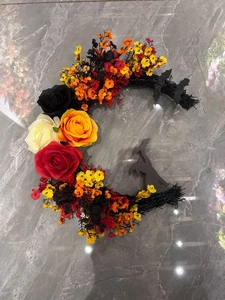 Macro shot of Halloween crescent wreath with roses, bats and a witch silhouette