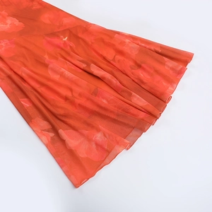 Détail de l'ourlet en tulle à imprimé floral rouge avec une conception en tissu doublé