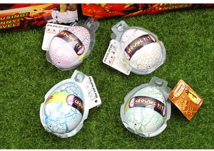 Detailed view of four colorful cracked dinosaur eggs on green grass for water hatching