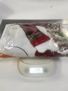 Christmas chair cover in red and plaid patterns, weighted on an electronic scale