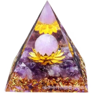 Macro detail of orgone pyramid with amethyst stones, golden lotus and gold foil base