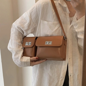 Close-up of brown dual-compartment baguette bag with silver metal swivel lock detail