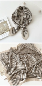 Detail of champagne and black geometric silk scarf with fine twill texture and knots