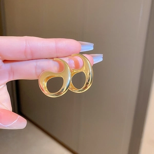 Detailed macro view of gold geometric spiral earring with a high-polished metallic finish