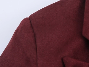 Macro detail of wine red faux suede fabric showing shoulder seam and soft matte texture