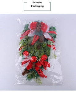 Christmas swag detail with red bow pine cones and bells in retail clear packaging