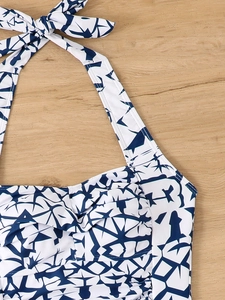 Detail view of navy blue geometric print halter bikini top on a wooden surface