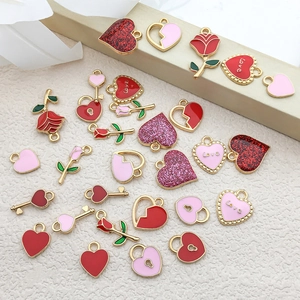 Flat lay of colorful heart and rose alloy pendants with gold borders on beige background