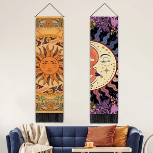 Detail of sun and moon mandalas on fabric tapestries with black tassels and wood rods