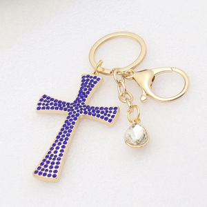 Detailed view of golden cross keychain featuring blue rhinestones and lobster clasp