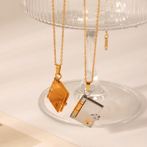 Detailed view of gold and silver book-shaped locket necklaces with heart cutout design