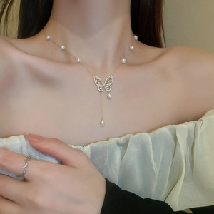 Detail of gold butterfly tassel necklace with freshwater pearls and sparkling zircons