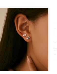 Detailed close-up of butterfly stud earrings with pink blue stones and silver plating