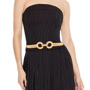 Detail of a thin gold metal spring waist belt with double circular rings on a model