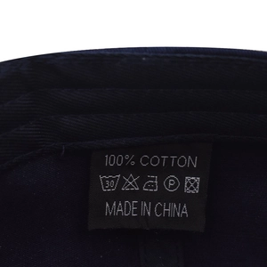 Macro detail of the 100% cotton washing label inside the navy washed baseball cap